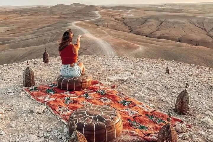 Solo traveller looking over the Agafay Desert canyon at sunset near Marrakech