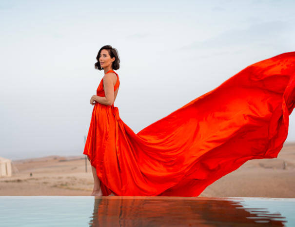 Red flying dress photoshoot by an infinity pool in the Agafay desert