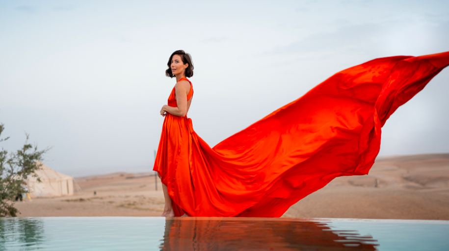 Red flying dress photoshoot by an infinity pool in the Agafay desert